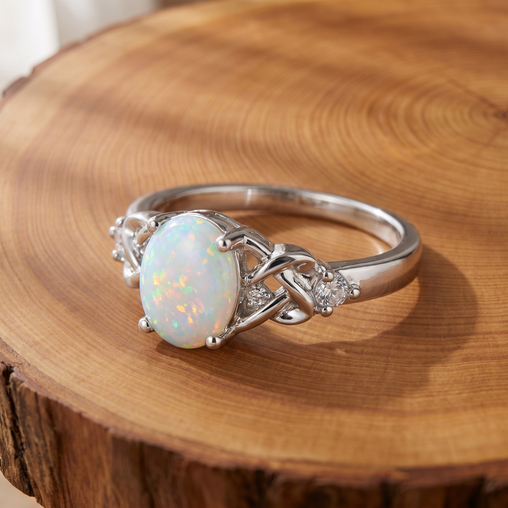 White Opal Celtic Knot Silver Ring on a wooden slice